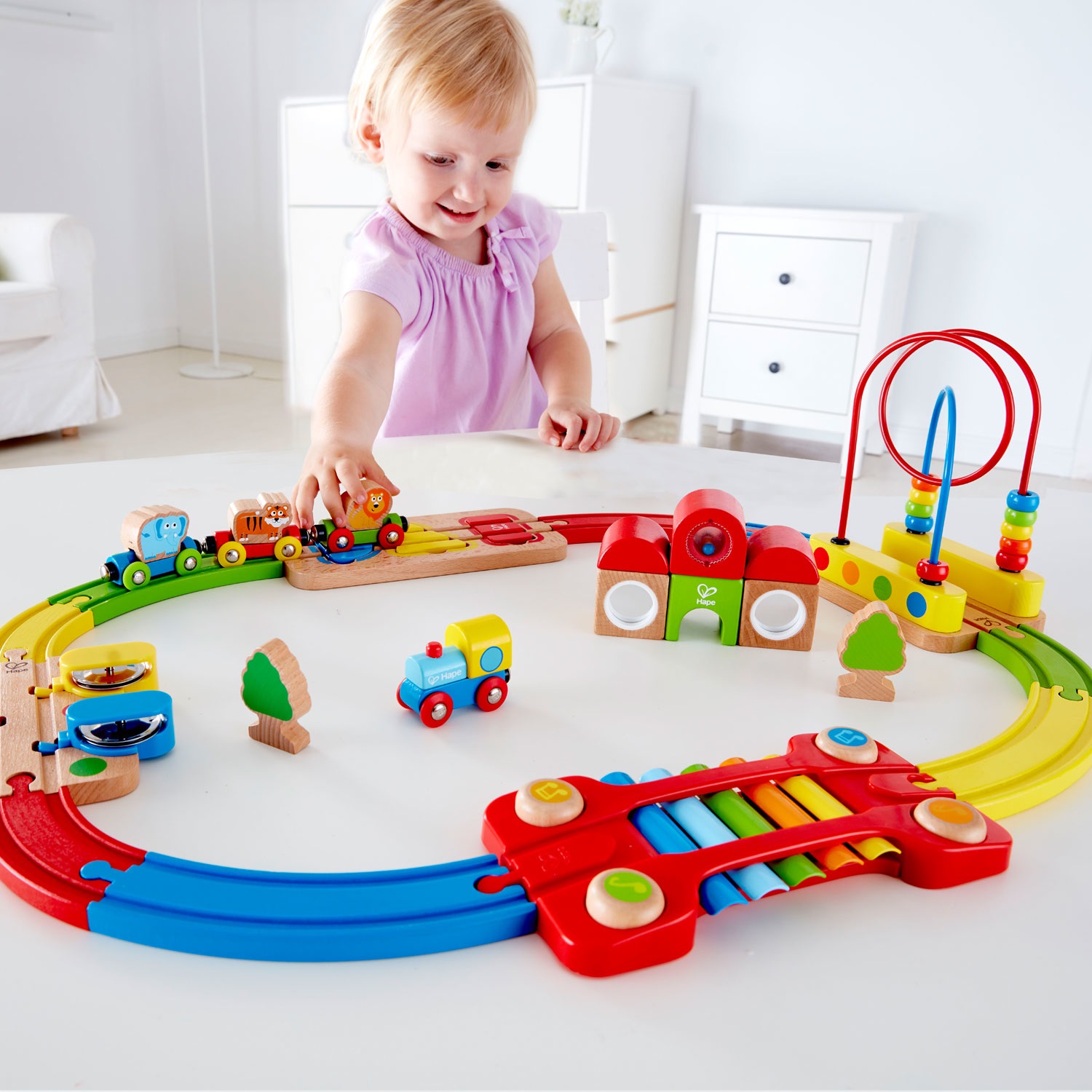 Hape E3826 Pista Treno Arcobaleno - Giocattolo Educativo per Sviluppare Abilità Motorie, Puzzle Ferrovia con Binari Colorati e Strumenti Musicali, Adatto dai 18 Mesi