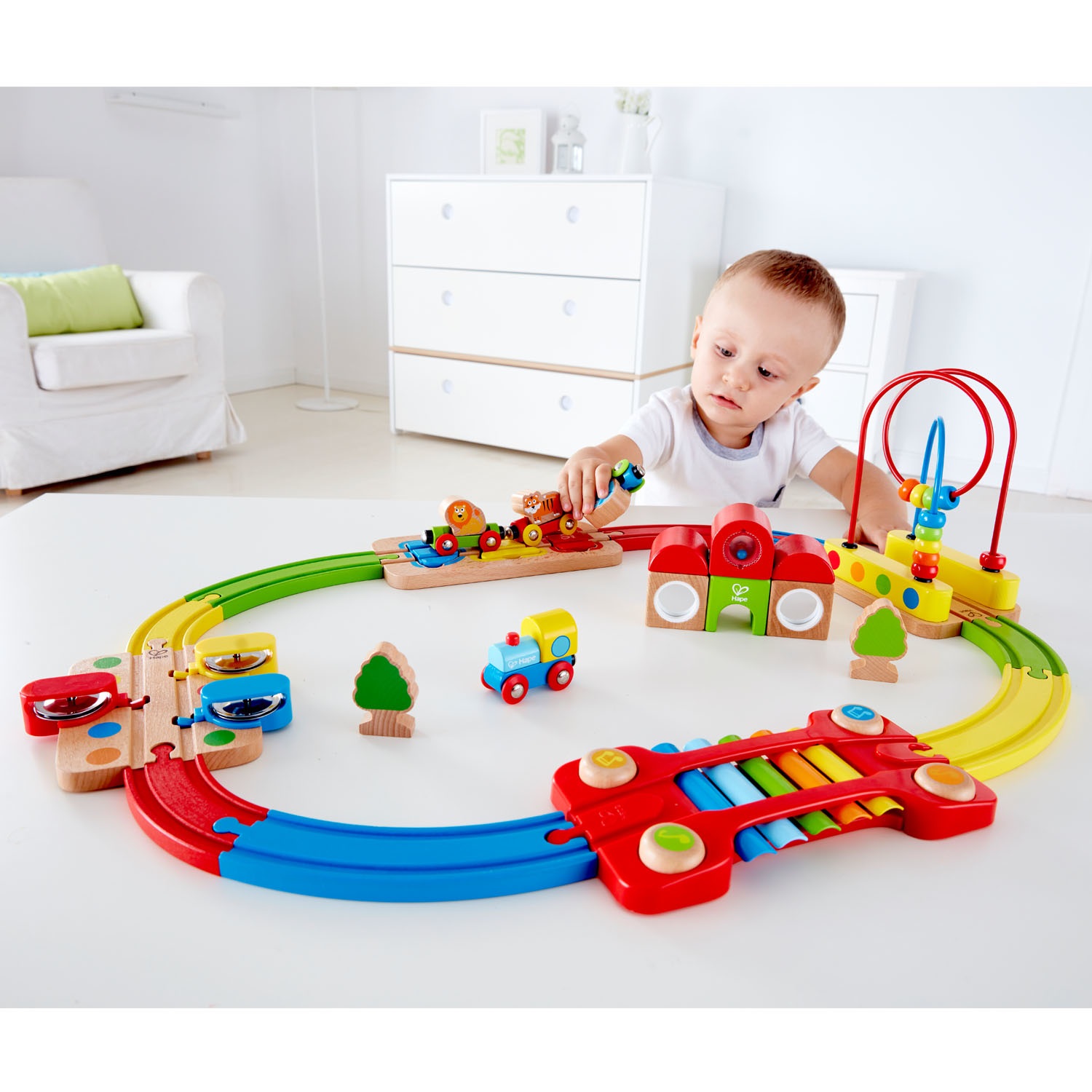 Hape E3826 Pista Treno Arcobaleno - Giocattolo Educativo per Sviluppare Abilità Motorie, Puzzle Ferrovia con Binari Colorati e Strumenti Musicali, Adatto dai 18 Mesi